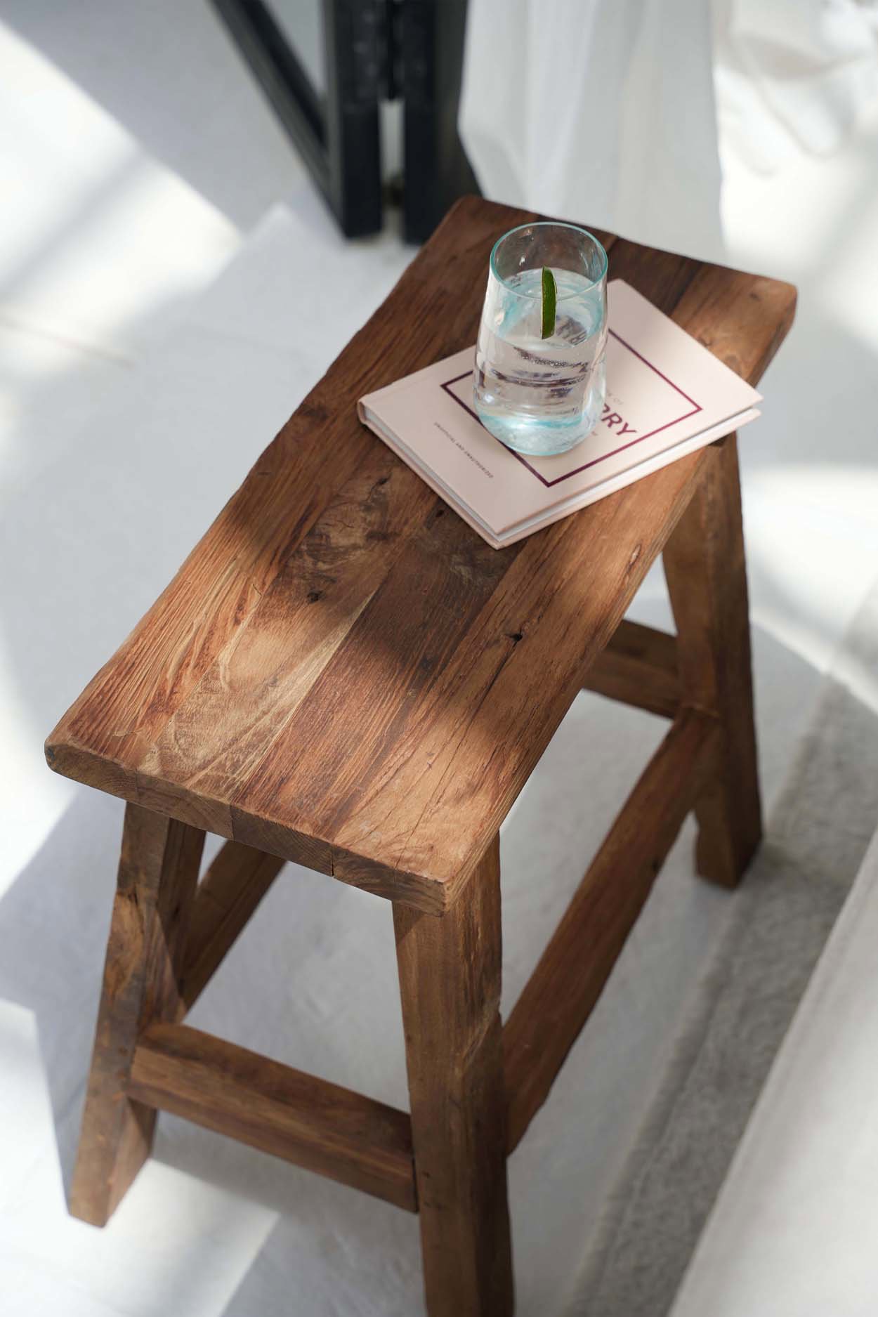 Tabouret Fab Rustic présenté devant un canapé, vue de face.