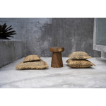 Quatre coussins carrés beige à côté dun tabouret en bois sur fond gris