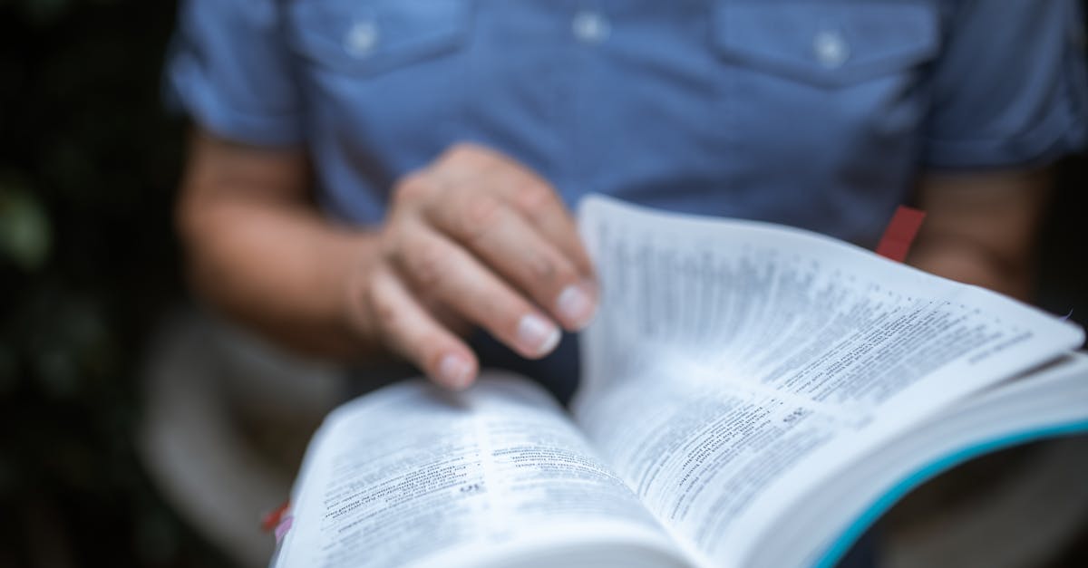 personne en bleu livre de lecture de chemise boutonnee