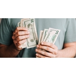 Crop man counting dollar banknotes