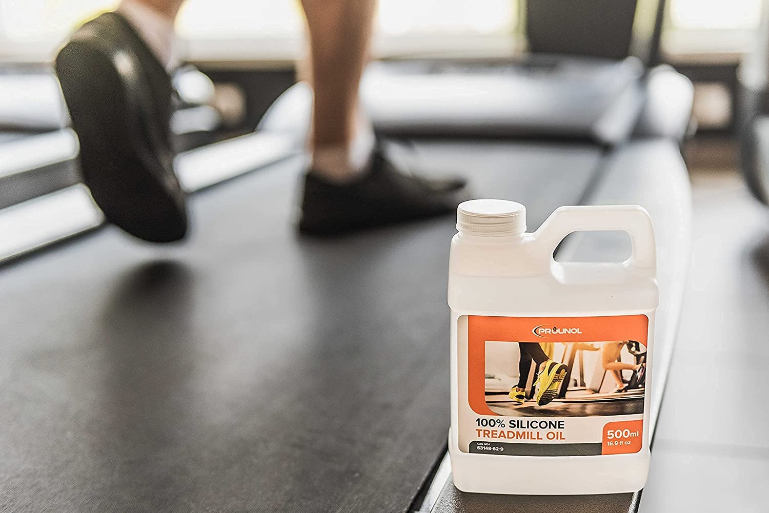 A bottle of tread cleaner, a product used for maintaining and cleaning treadmills, sitting on a treadmill.