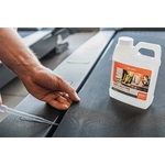 Description: Gérez produits - A person using a bottle of cleaner on a treadmill.
