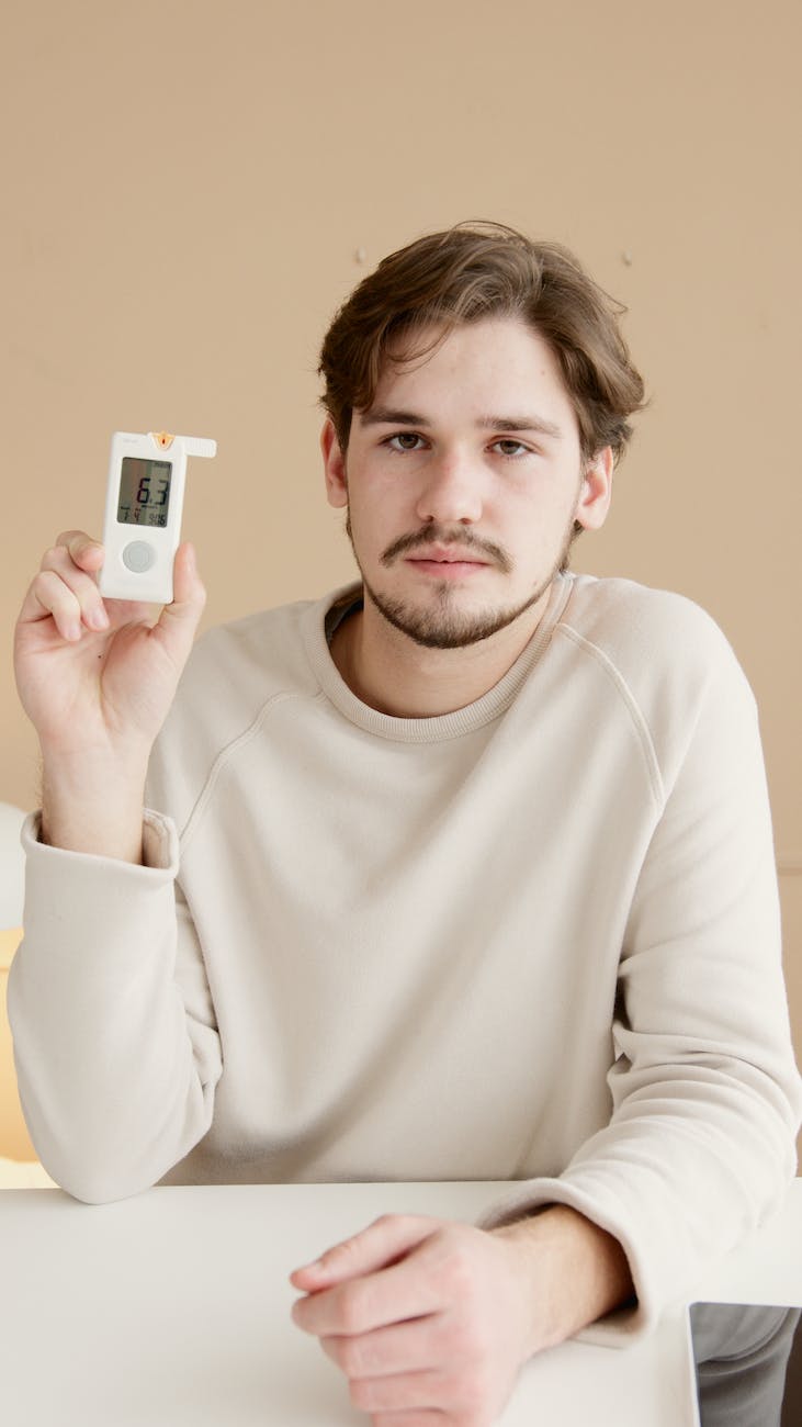 young man holding a glucometer
