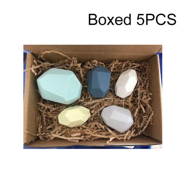 Child choosing a stone from the set showing variety of sizes