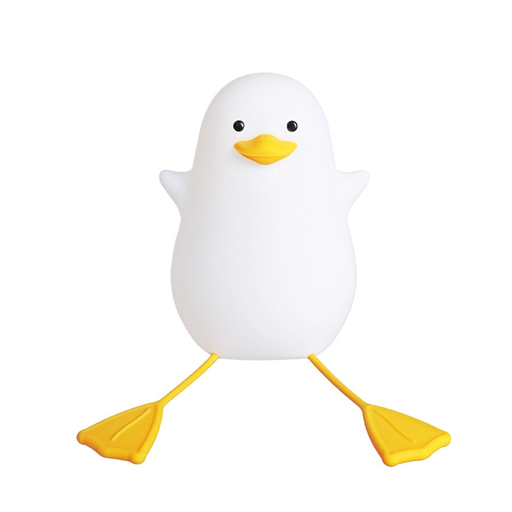 Happy Duck lamp glowing on a bedside shelf at night