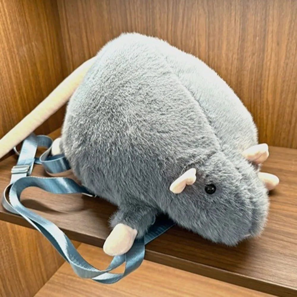 Child putting a small book into the Chubby Mouse Plush Backpack