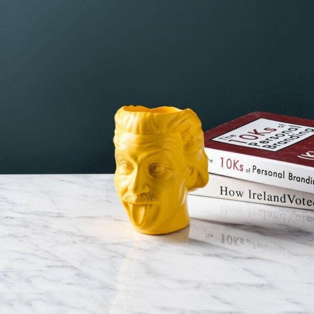 Portrait vase placed next to a laptop as a pen holder