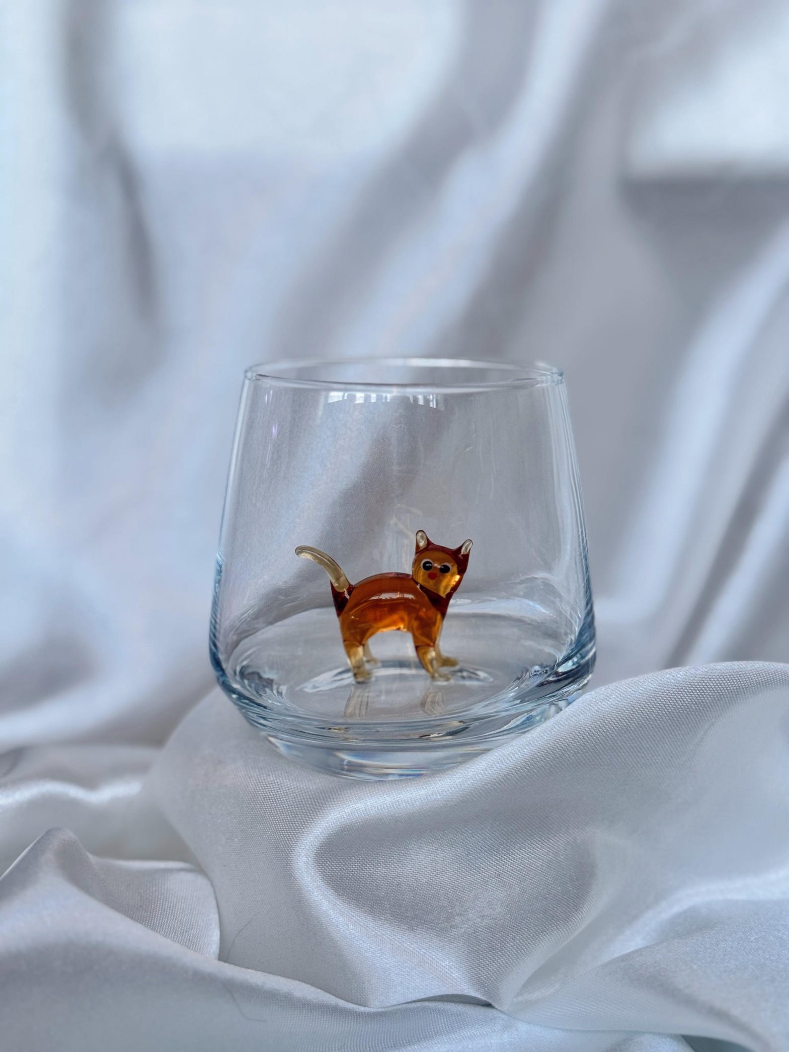 Side shot showing the curve of the bowl and the kitty inside the glass