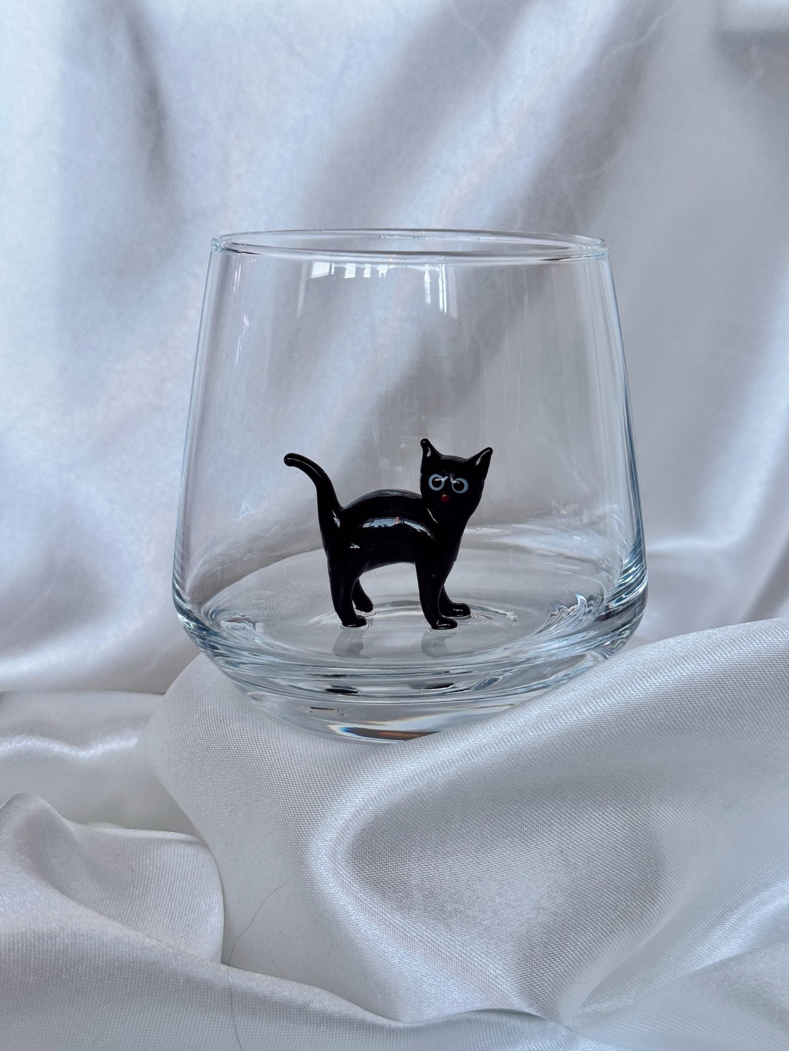 Murano cup on a wooden tabletop with light shining through the glass
