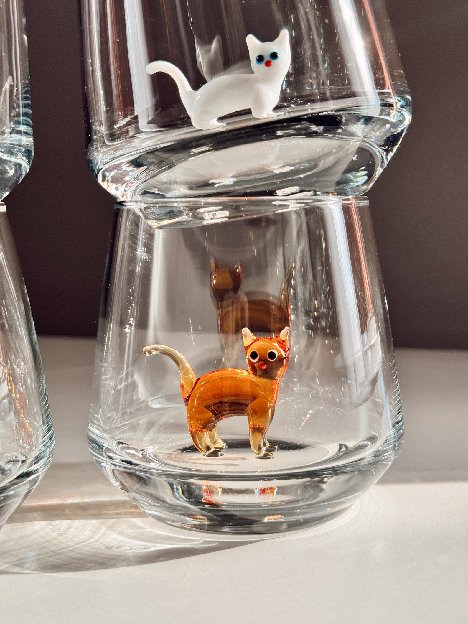 Delicate glass rim of a Murano stemless cup with tiny kitty inside