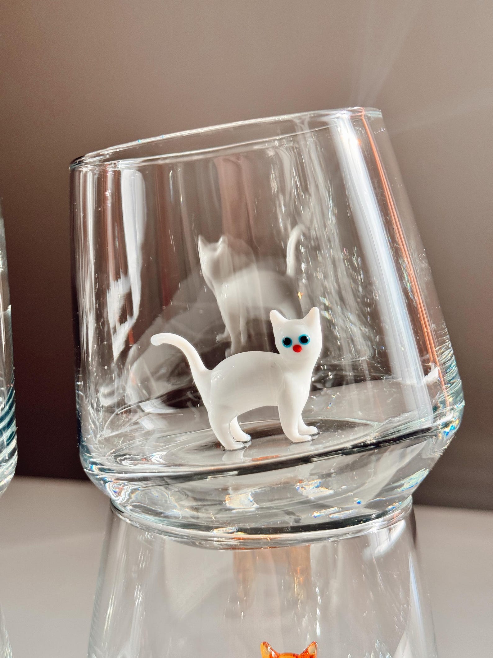 Close-up of kitty figurine with playful expression inside the glass