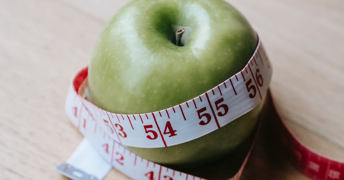 green apple with measuring tape on table in kitchen