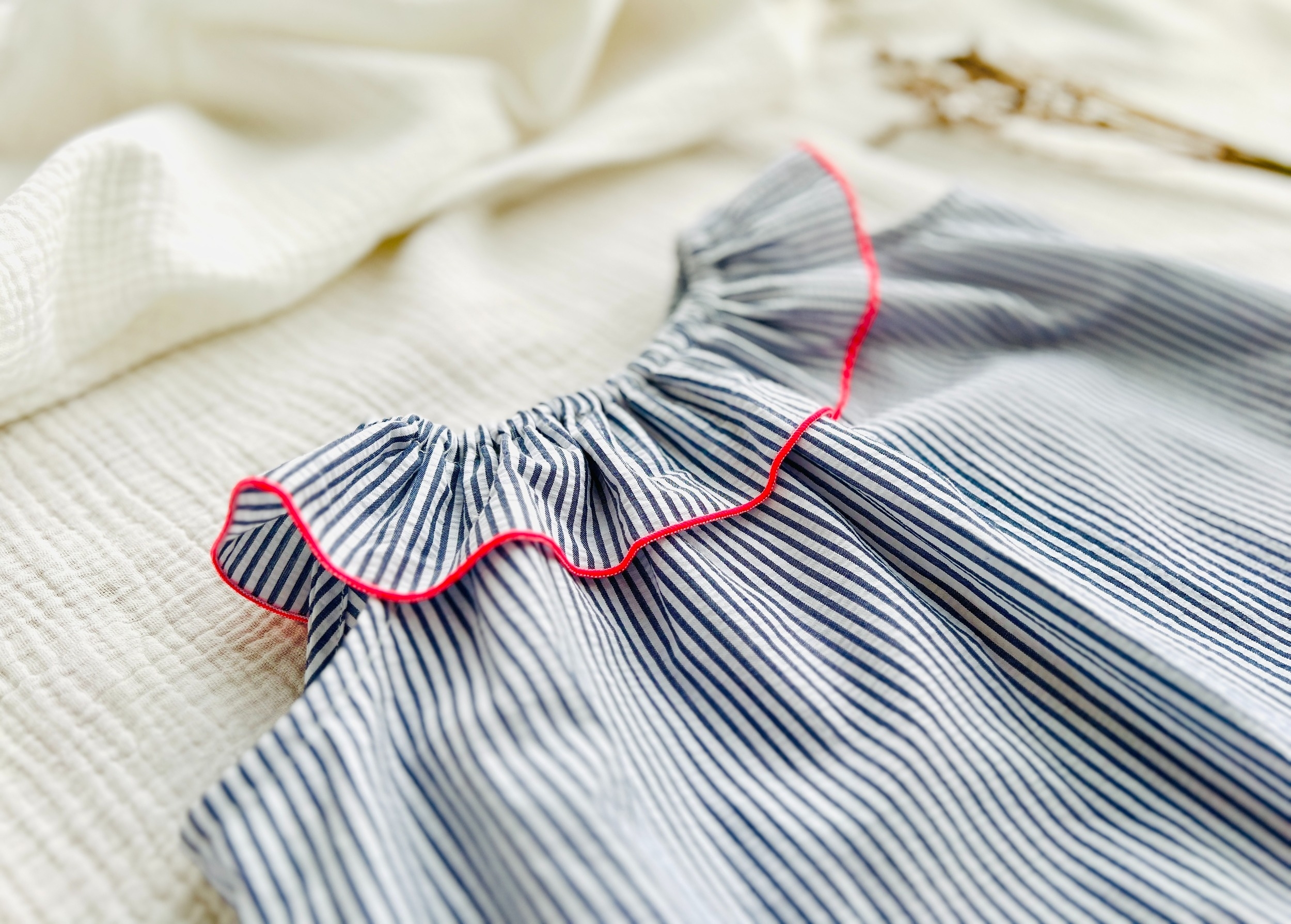 blouse seersucker rayé marine et roulotté rose fluo
