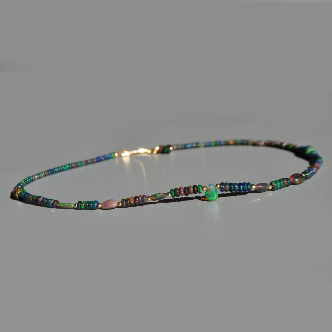 Collier opale noire dÉthiopie à plat, vue de profil avec la goutte verte centrale