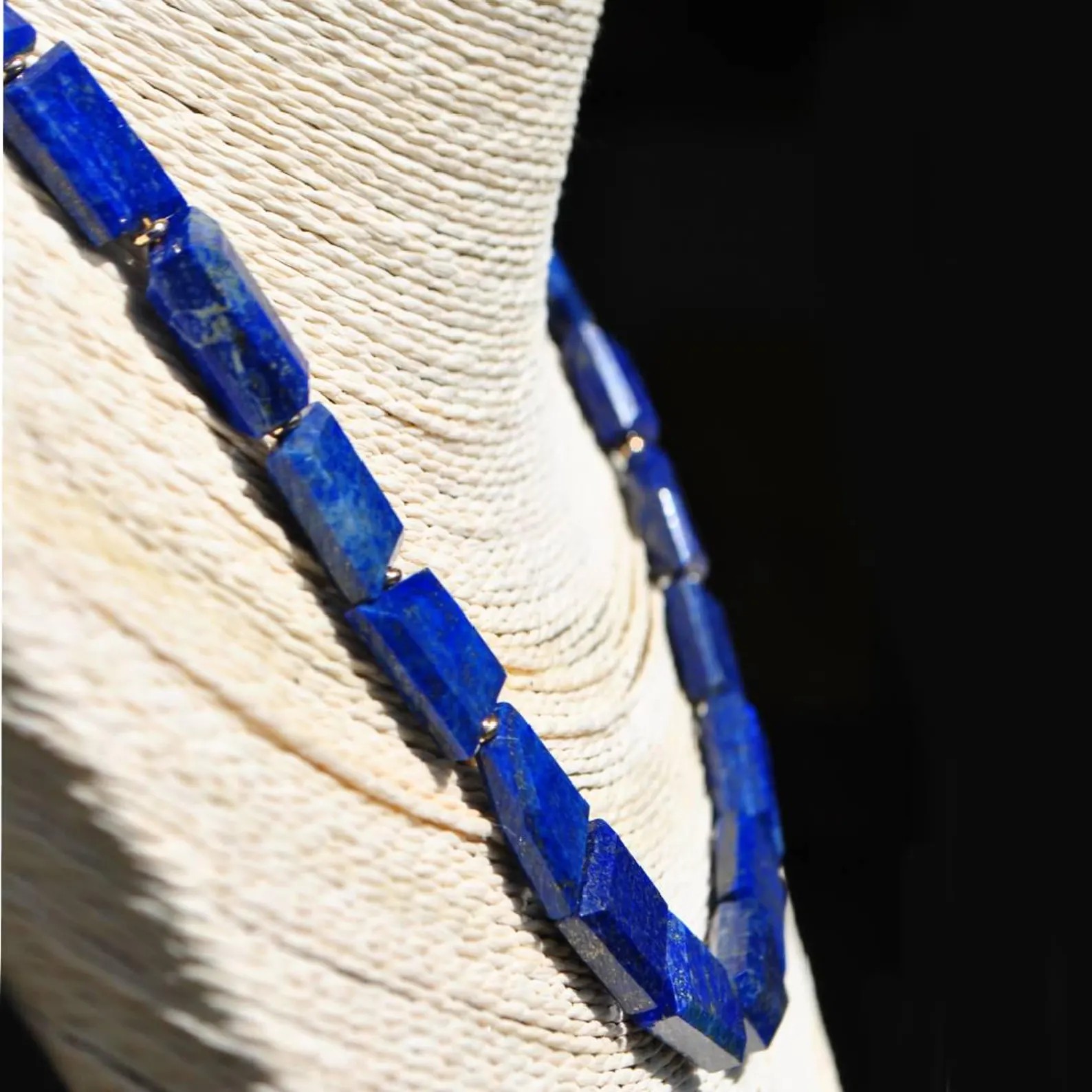 Collier lapis lazuli sur buste vu de profil, facettes en biseau des pierres