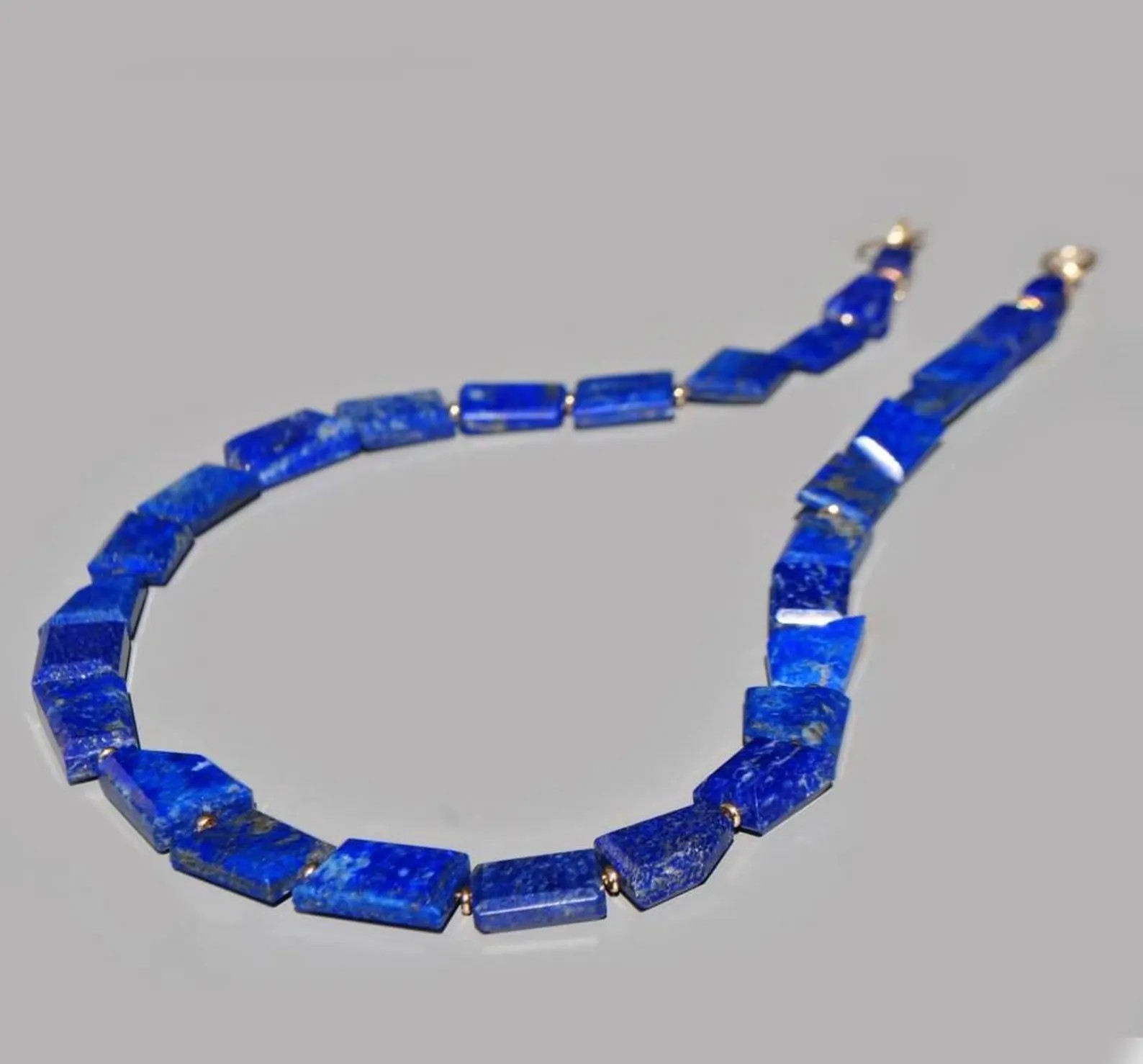 Collier lapis lazuli posé à plat, pierres taillées dun bleu intense