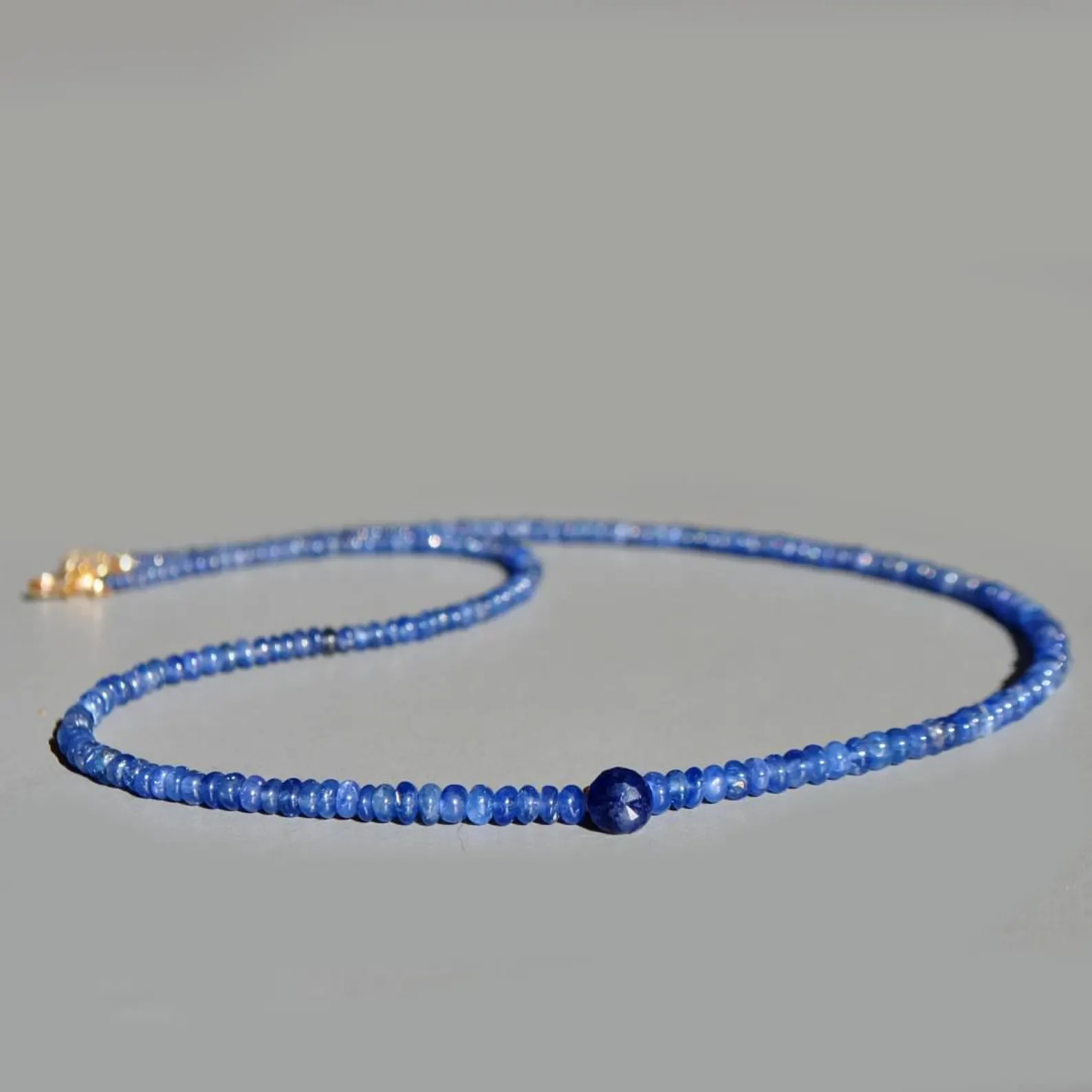 Collier fin en saphir bleu posé, rondelles bleues et saphir facetté au centre