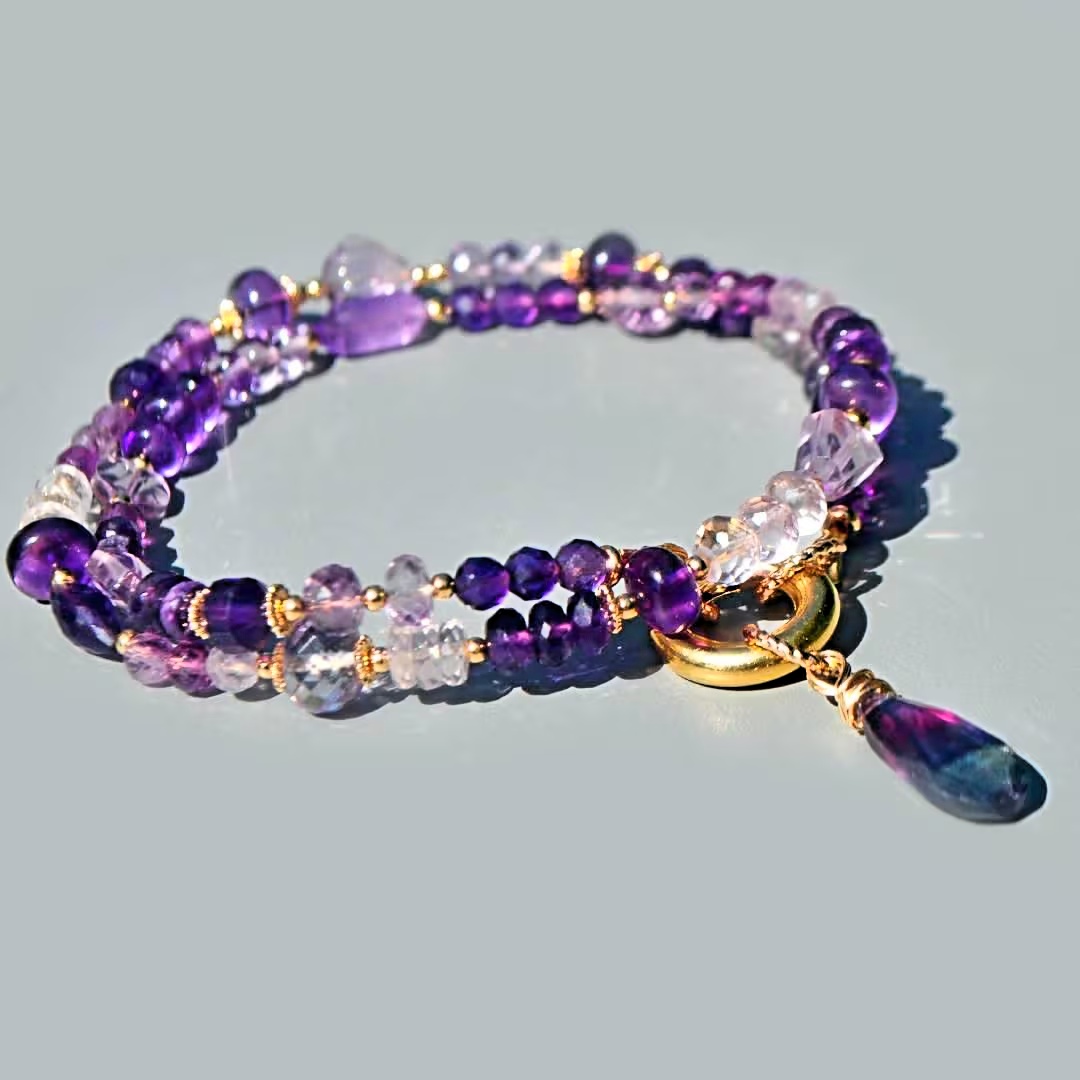 Collier améthyste violette, fermoir rond mousqueton doré et goutte de fluorite en gros plan