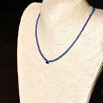 Collier saphir bleu porté sur buste, goutte centrale à la base du cou