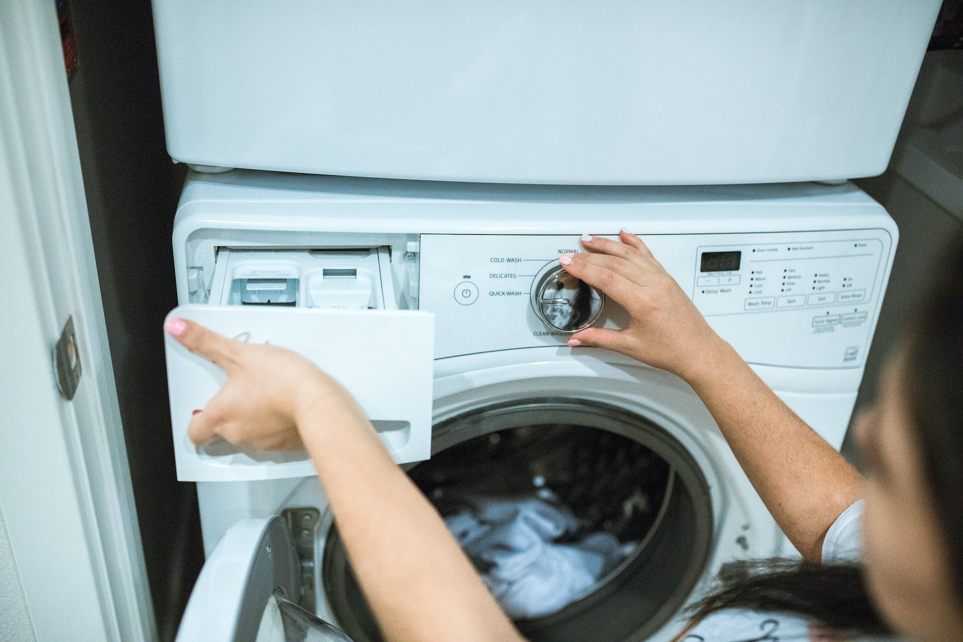 personne tenant une machine a laver a chargement frontal blanc