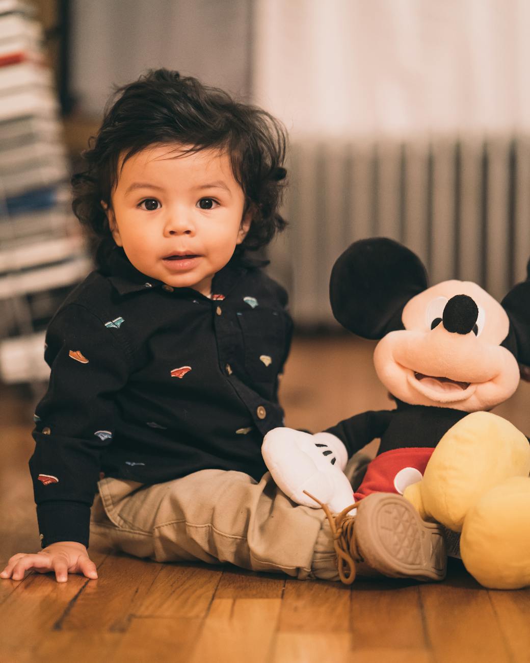 enfant assis jouant a la peluche mickey mouse