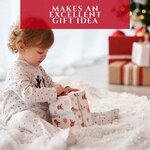 Petite fille qui ouvre un cadeau de Noel