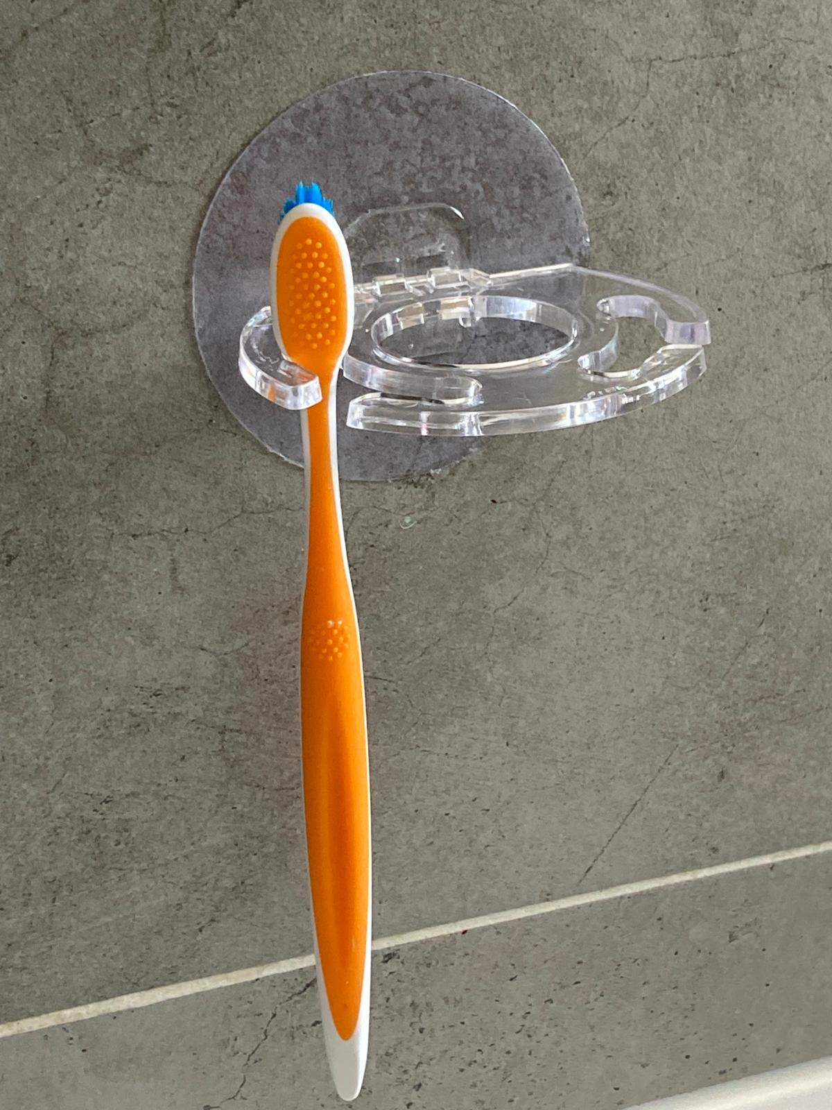 Porte-brosse à dents et dentifrice mural adhésif transparent discret brosse à dent orange.