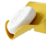 Supports savon solide, jaune fixé au mur.