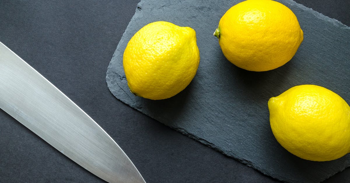 photo de trois citrons sur une planche a decouper pres d un couteau