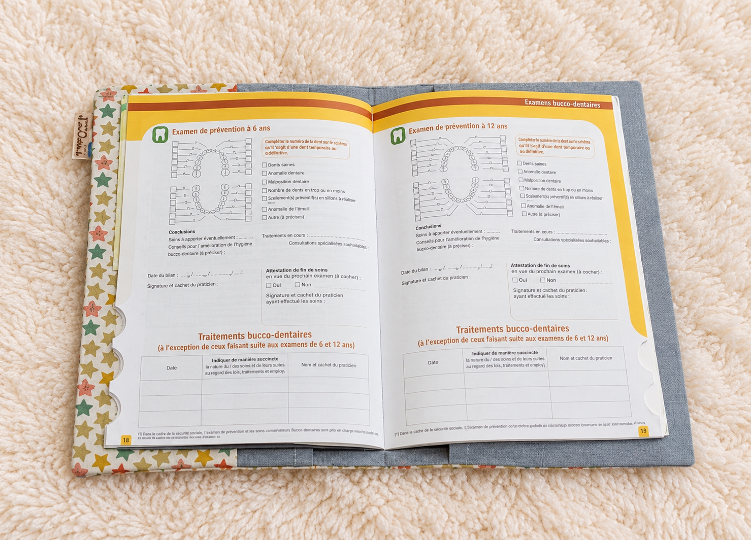 Carnet dentaire ouvert sur tapis écru