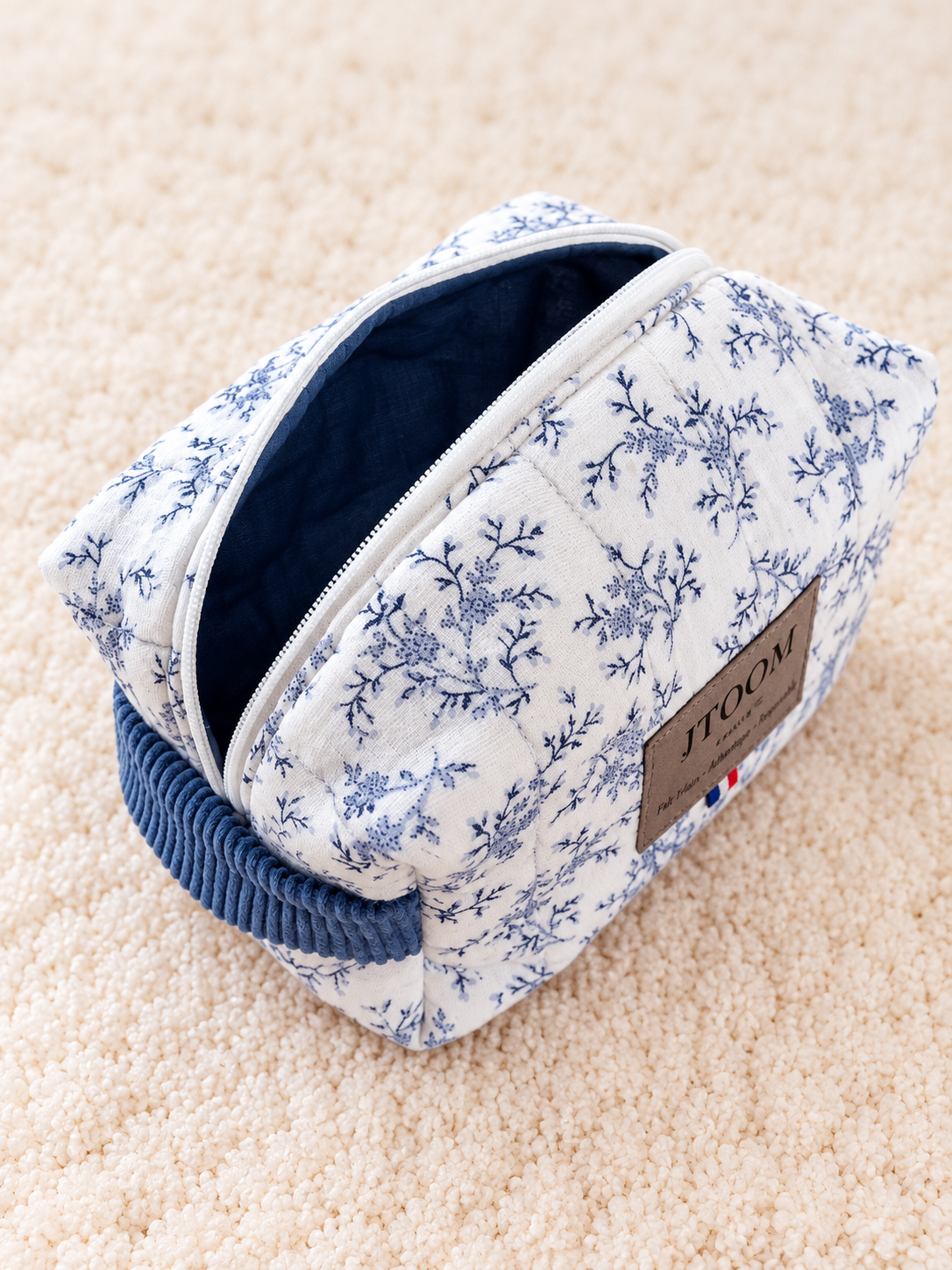 Pochette matelassée JTOOM sur tapis crème
