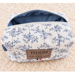 Trousse florale bleu poudré sur tapis crème