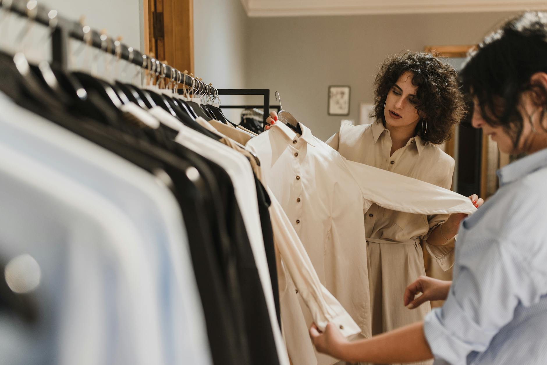 femme en robe blanche debout pres de porte vetements