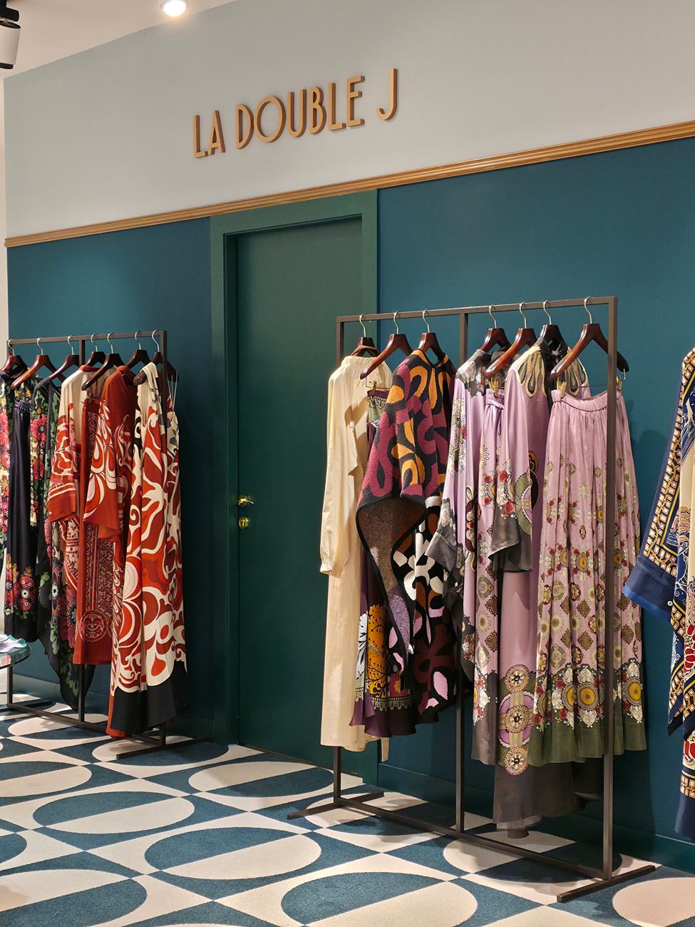 interieur d une boutique de mode avec des portants a vetements colores et un sol au design geometrique