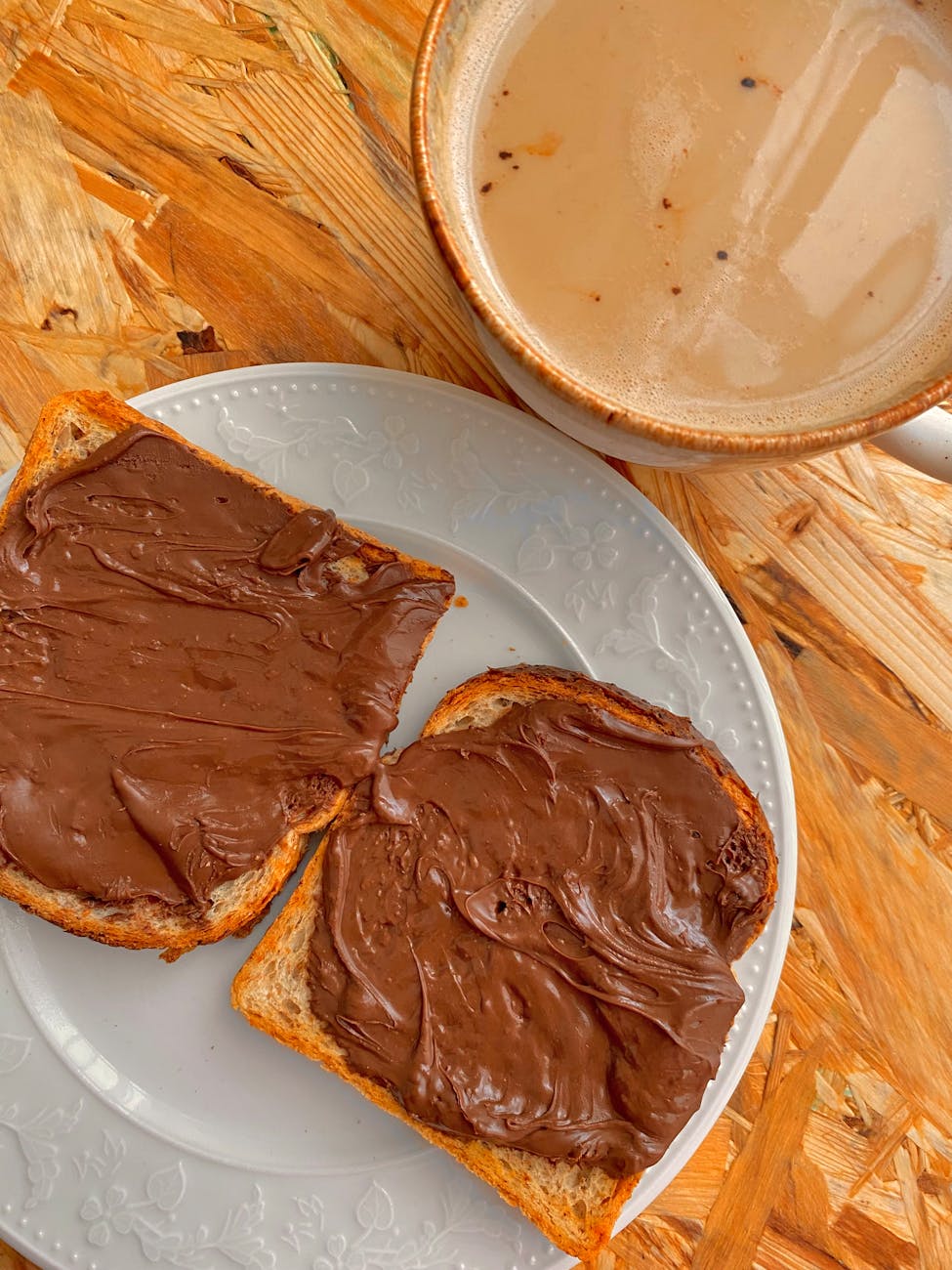Délicieuse tartinade au chocolat sur du pain grillé accompagnée dune boisson chaude, parfait petit-déjeuner réconfortant