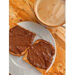 Délicieuse tartinade au chocolat sur du pain grillé accompagnée dune boisson chaude, parfait petit-déjeuner réconfortant