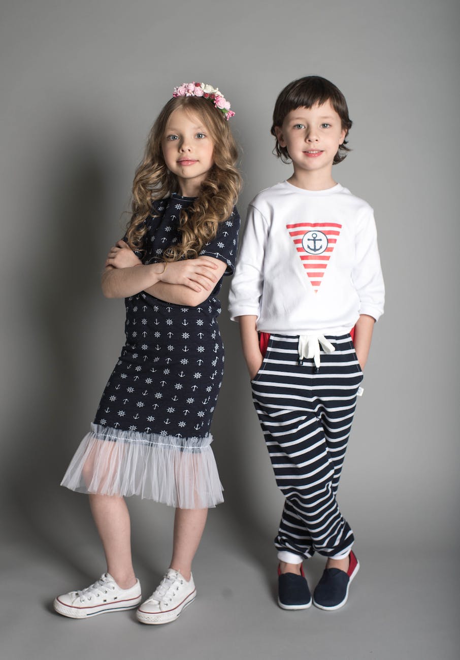Fille En Robe Noire Debout à Côté D'une Fille En Sweat Shirt Blanc Et Pantalon Rayé Noir