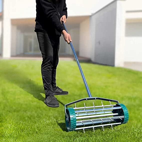 homme-passant-rouleau-aerateur-gazon