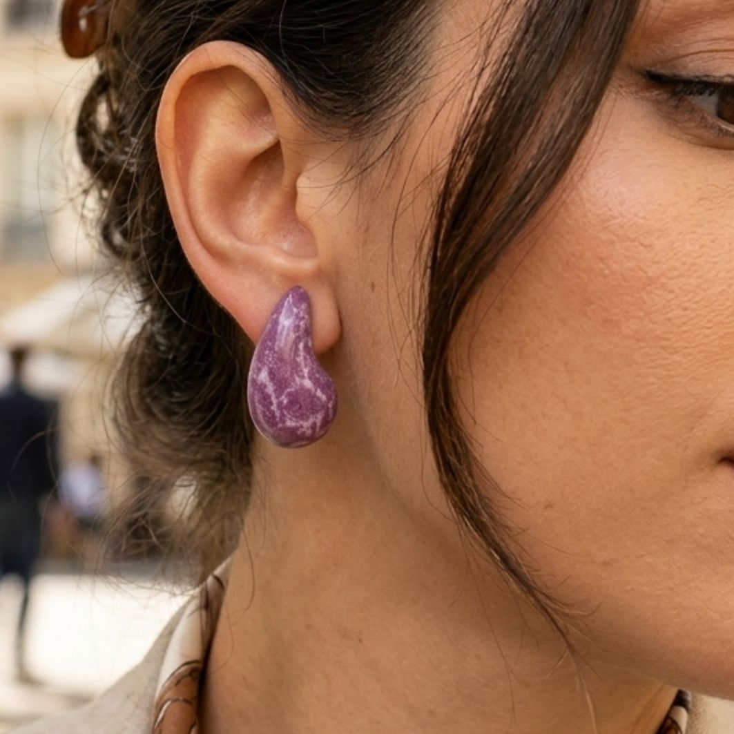 boucles doreilles gouttes incuvées magenta portées en béton