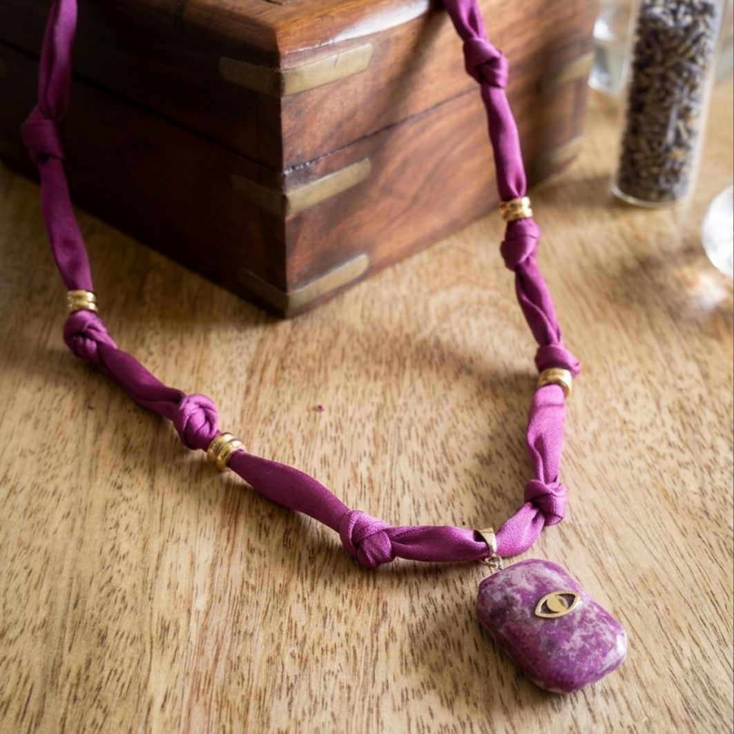 collier intuition pendentif en béton marbré fuchsia avec oeil doré et cordon noué rose fuchsia