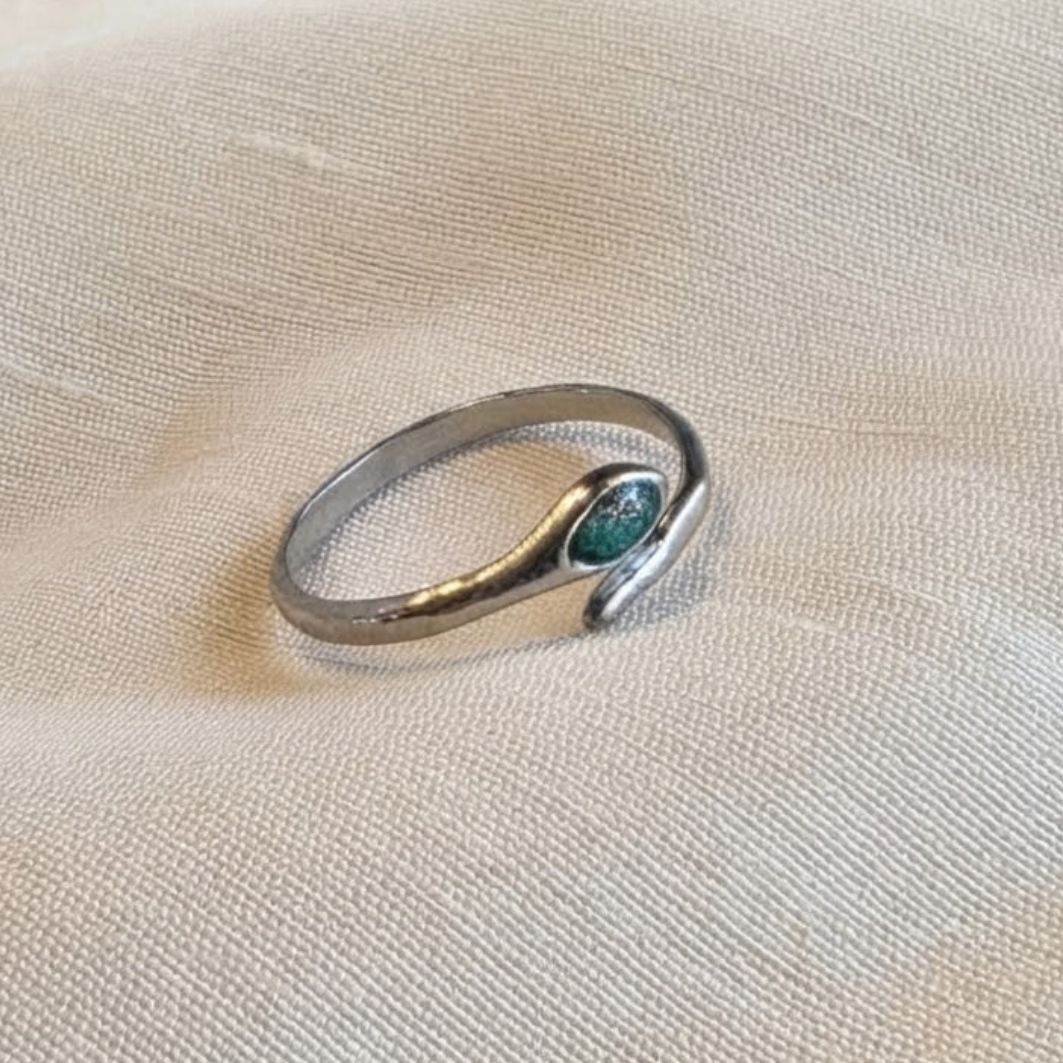Bague Tiya ajustable en acier inoxydable argenté, pierre en béton irisé bleu-vert, posée sur lin