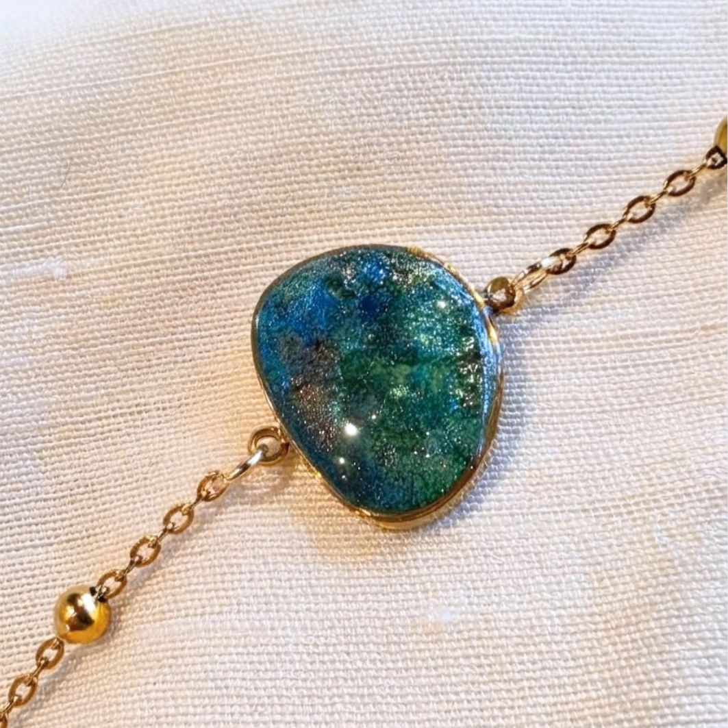 Bracelet Nour, détail de la pierre en béton irisé bleu-vert sertie sur chaîne dorée