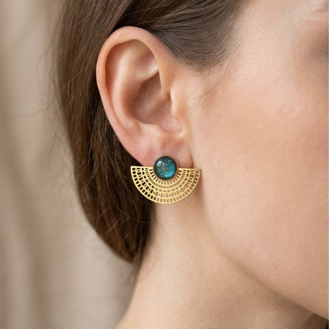 Paire de boucles doreilles Scribe en acier doré et béton irisé sur lin beige