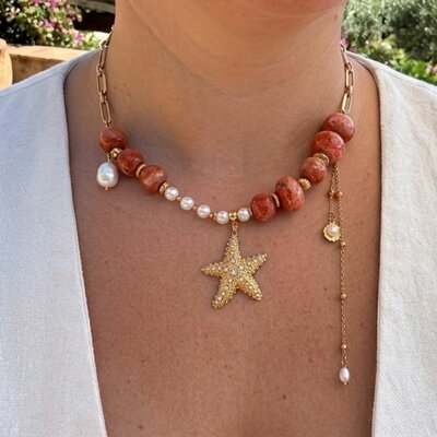 Collier Soleil de nacre. perles en bétonmarbré orange et étoile de mer strassée porté