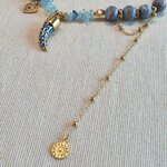 détail collier amulette chaîne asymétrique