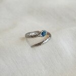 Bague Serpentine portée à la main, serpent argenté enroulé et pierre en béton irisé bleu-vert