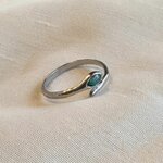 Bague Tiya ajustable en acier inoxydable argenté, pierre en béton irisé bleu-vert, posée sur lin