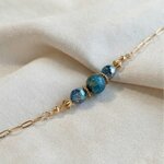 Bracelet Cristal Bleu porté au poignet, chaîne dorée et perles bleu-vert