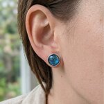 Puce doreille paon argentée en béton bleu irisé portée