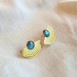 Boucle d'oreille Scribe portée, éventail doré ajouré et béton bleu irisé